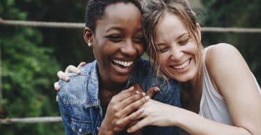 Duas mulheres abraçadas sorrindo