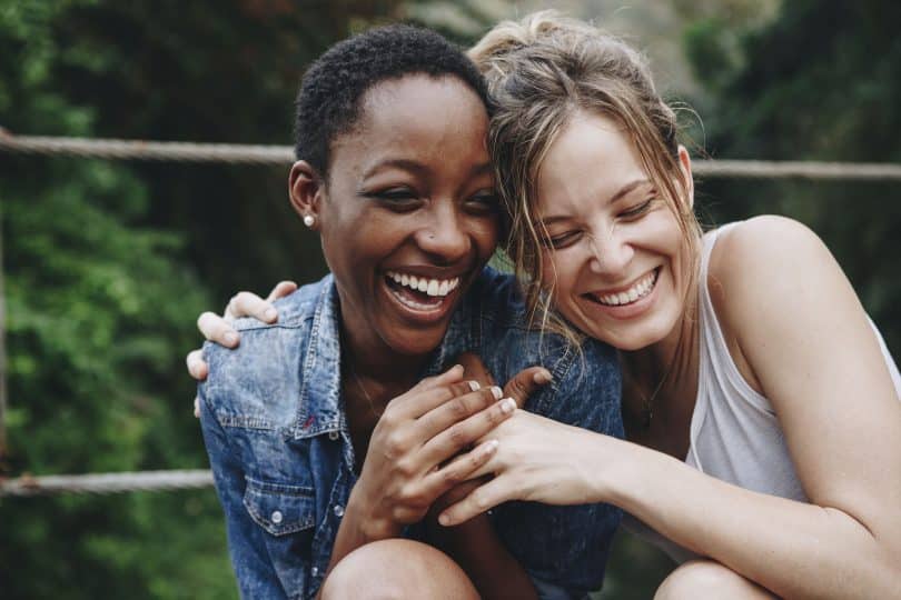 Duas mulheres abraçadas sorrindo