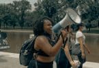 Mulher falando em um megafone em protesto