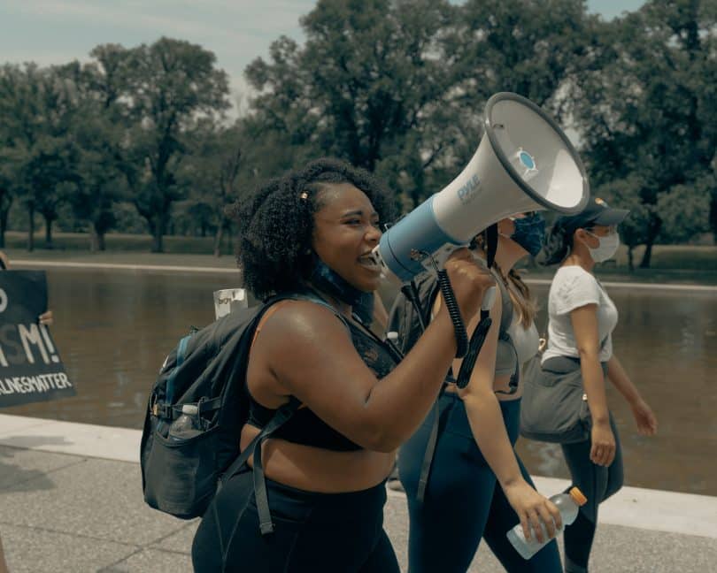 Mulher falando em um megafone em protesto