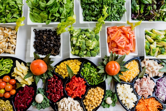 Mesa com pratos de itens para salada organizados visto de cima