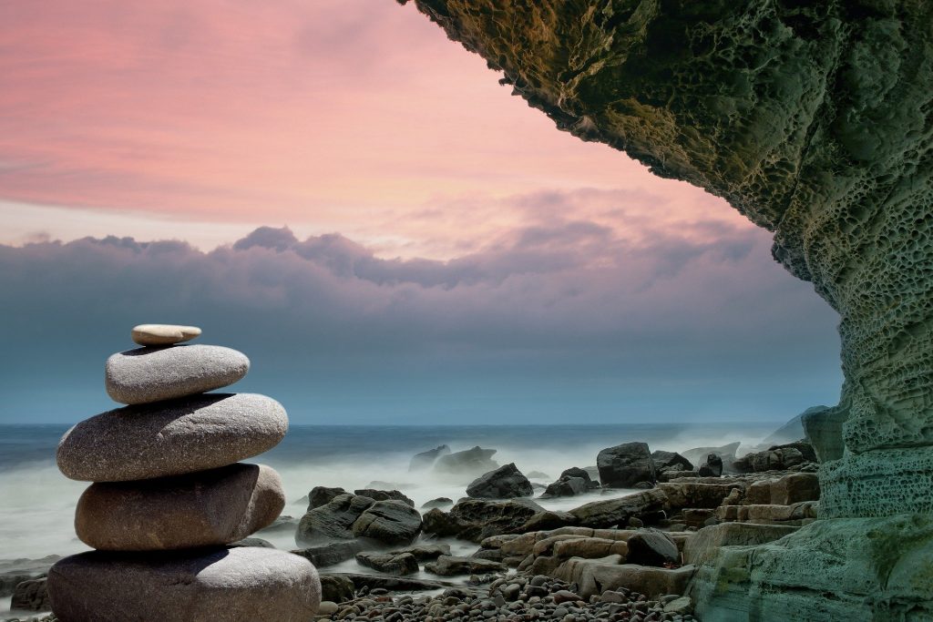 Imagem de várias pedras e uma de feng shui representando a espiritualidade e a física quântica.