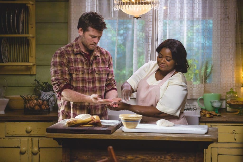 Homem cozinhando com mulher ao seu lado