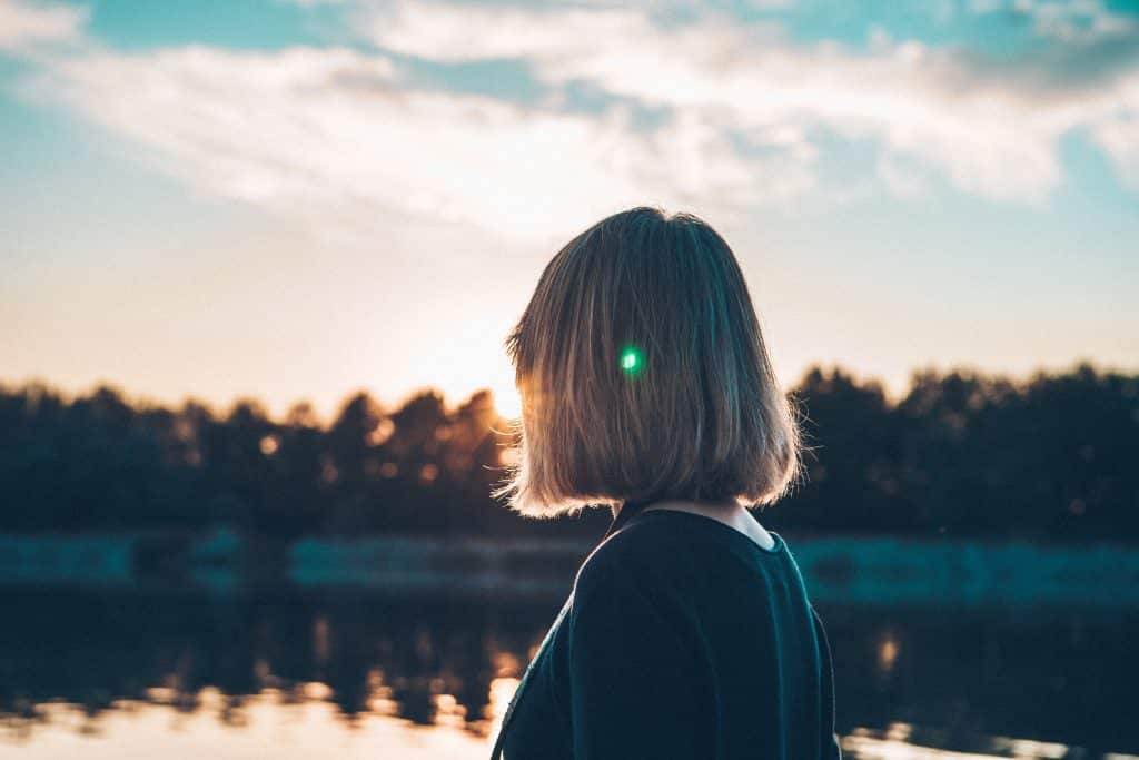 Mulher olhando em direção ao lado e ao sol