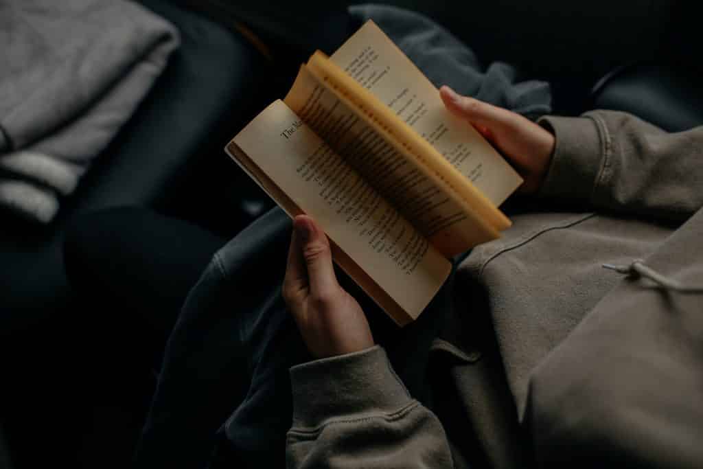 Homem deitado lendo livro