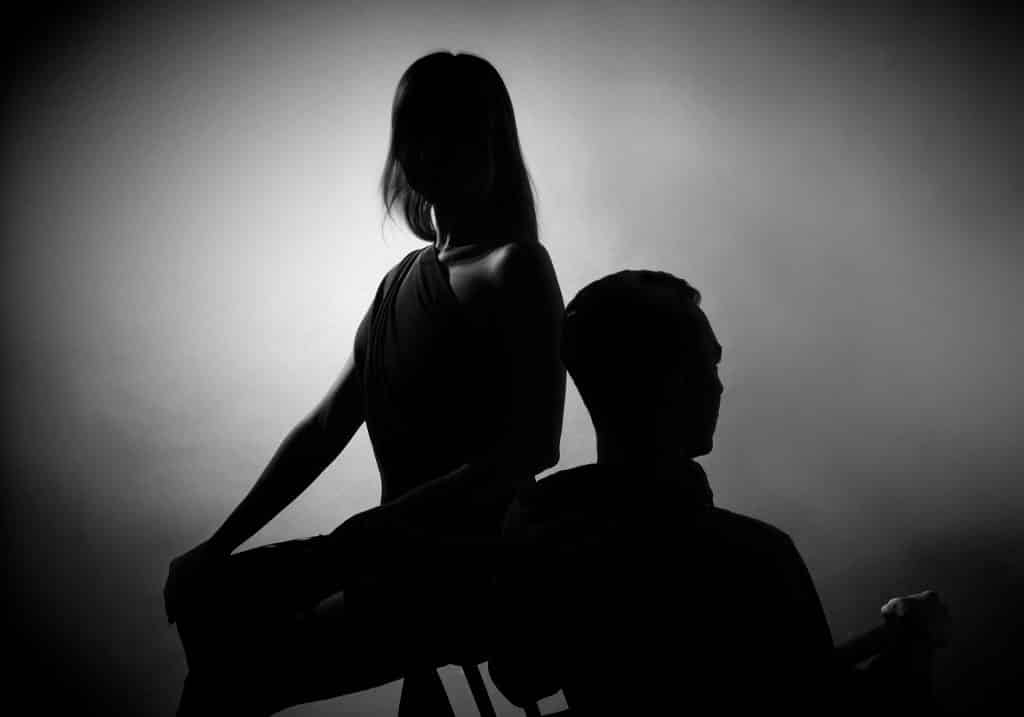 Imagem em preto e branco de um casal de homem e mulher, ambos aparentam estar ansiosos.
