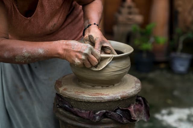 Senhora moldando vaso de barro