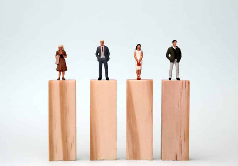 Figuras de quatro pessoas sobre blocos de madeira.