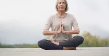 Mulher em posição de yoga com expressão de serenidade