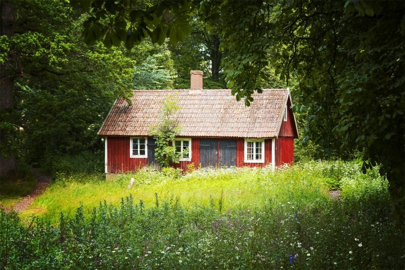 Casa vermelha em meio a floresta.