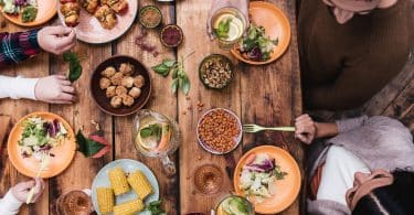 Mesa com pessoas comendo coisas saudáveis.