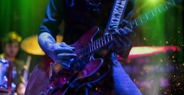 Músico tocando guitarra elétrica em um show de rock.