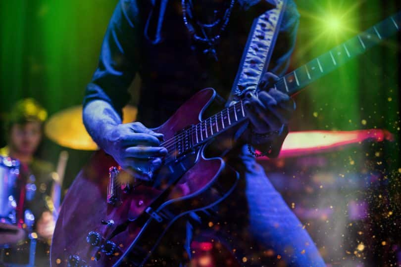 Músico tocando guitarra elétrica em um show de rock.