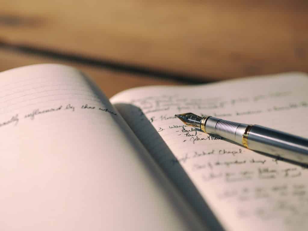 Caderno aberto com uma caneta em cima
