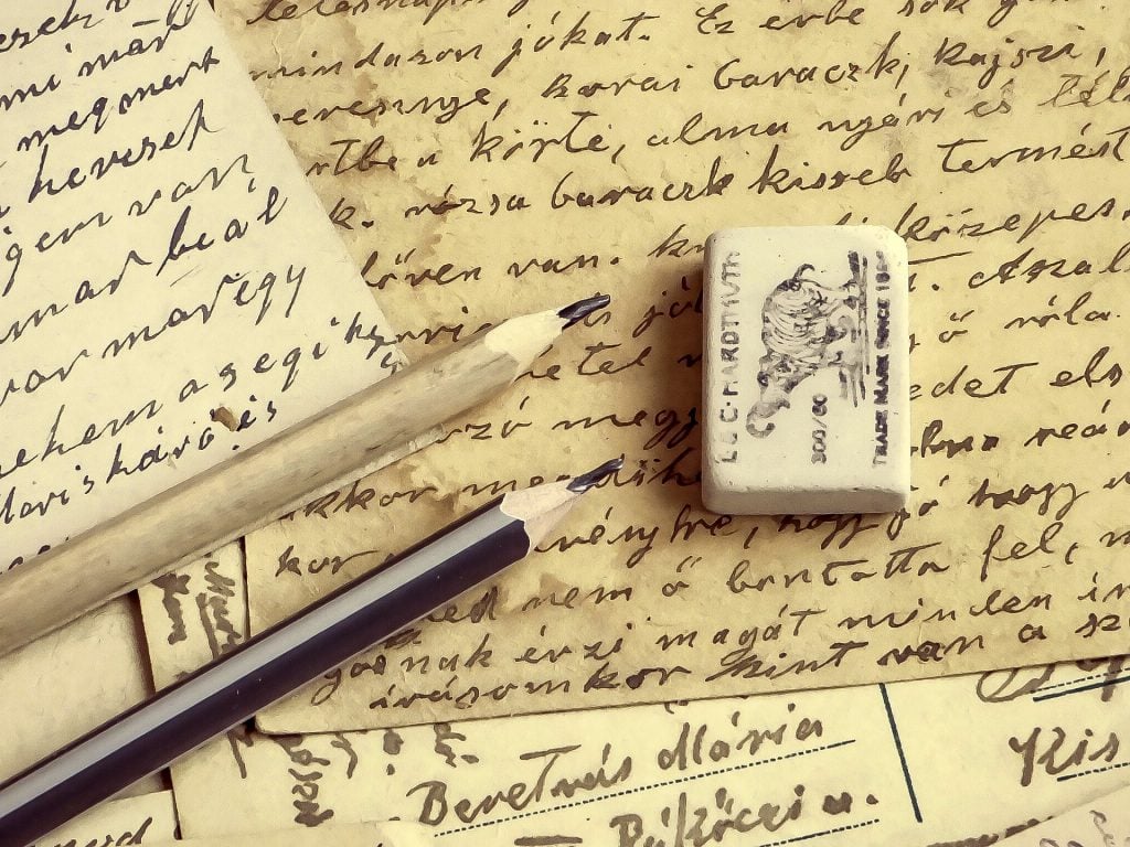 Imagem de um manuscrito antigo trazendo os resultados da missão Kepler. Ao lado dois lápis pretos e uma borracha.