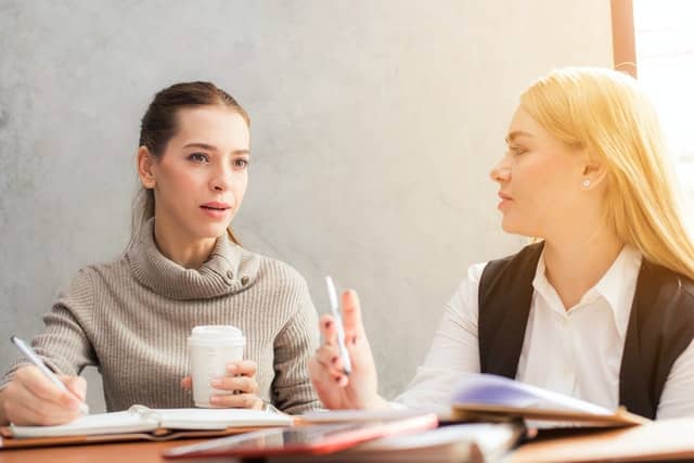 Mulheres conversando em mesa de trabalho