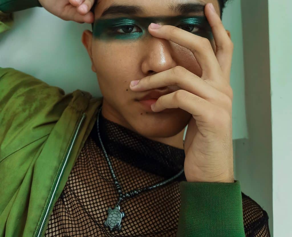 Homem usando uma tinta verde brilhante em volta dos olhos