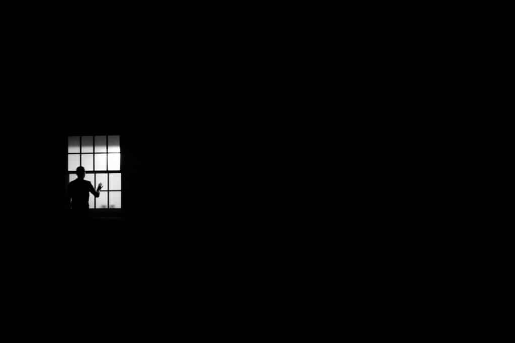 Silhueta de um homem olhando pela janela.
