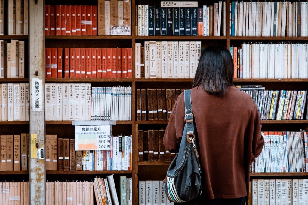 Mulher de costas numa biblioteca