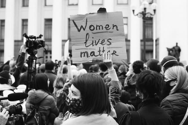 Movimento feminista com placa escrito "Women lives matter"