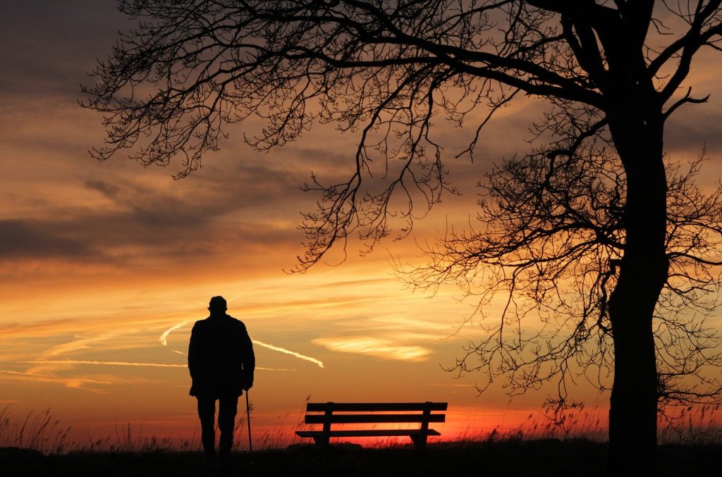 Imagem da silhueta de um homem representando Chico Xavier e ao fundo um lindo e vermelho por do sol.
