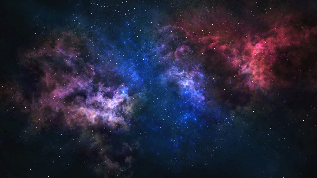 Imagem do céu estrelado representando o universo. A imagem traz cores azul, vermelho e violeta.
