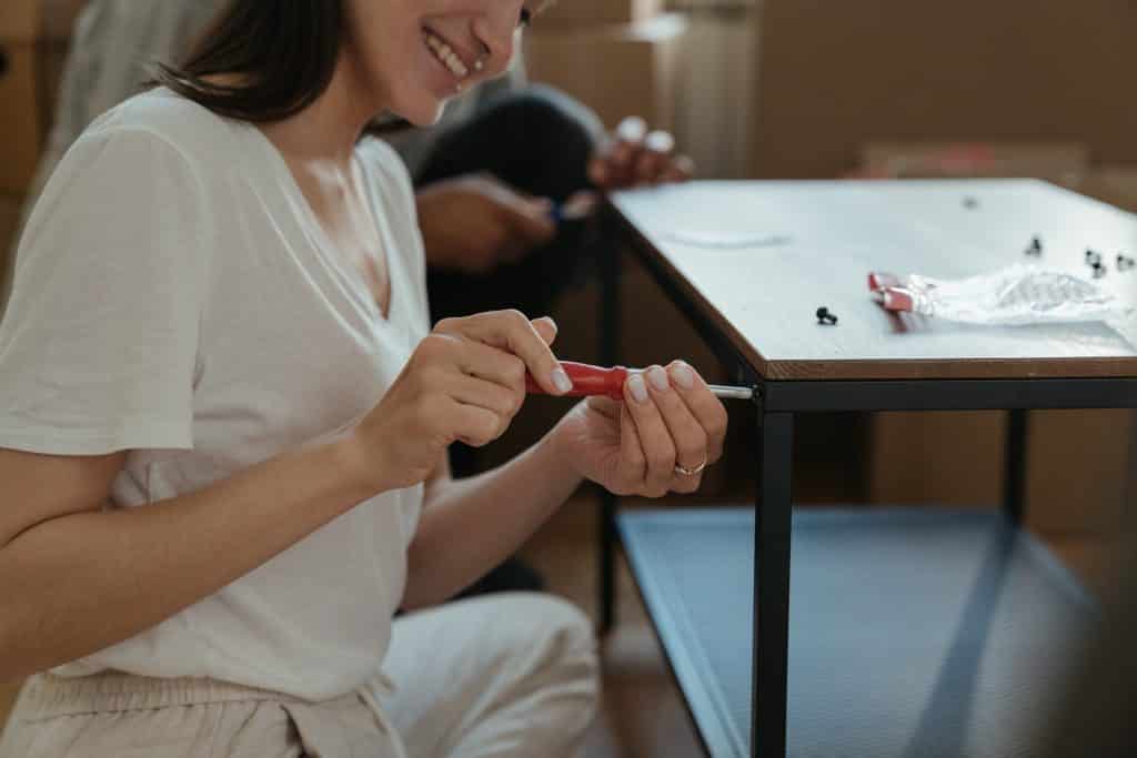 Mulher usando uma chave de fenda em uma mesa