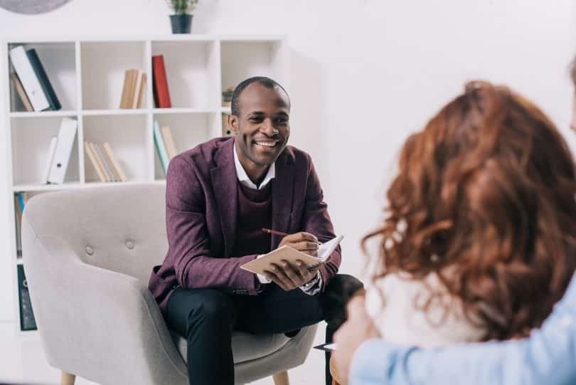 Psicólogo conversando com casal a sua frente