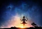Silhueta de menina em balanço olhando céu estrelado