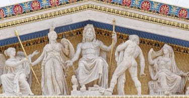 Imagem de várias estátuas de deuses gregos: dois sentados com tridentes nas mãos, e dois em pé.
