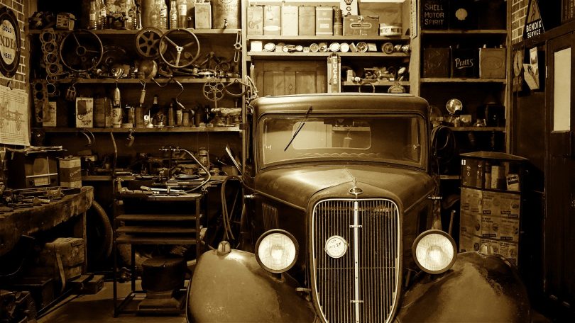 Imagem de um carro antigo estacionado dentro de uma garagem. Ele representa o que é sonhar com carro.