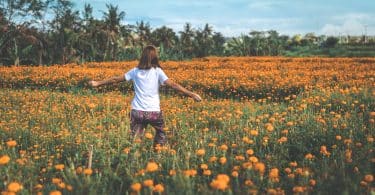 Mulher caminhando em um campo de flores