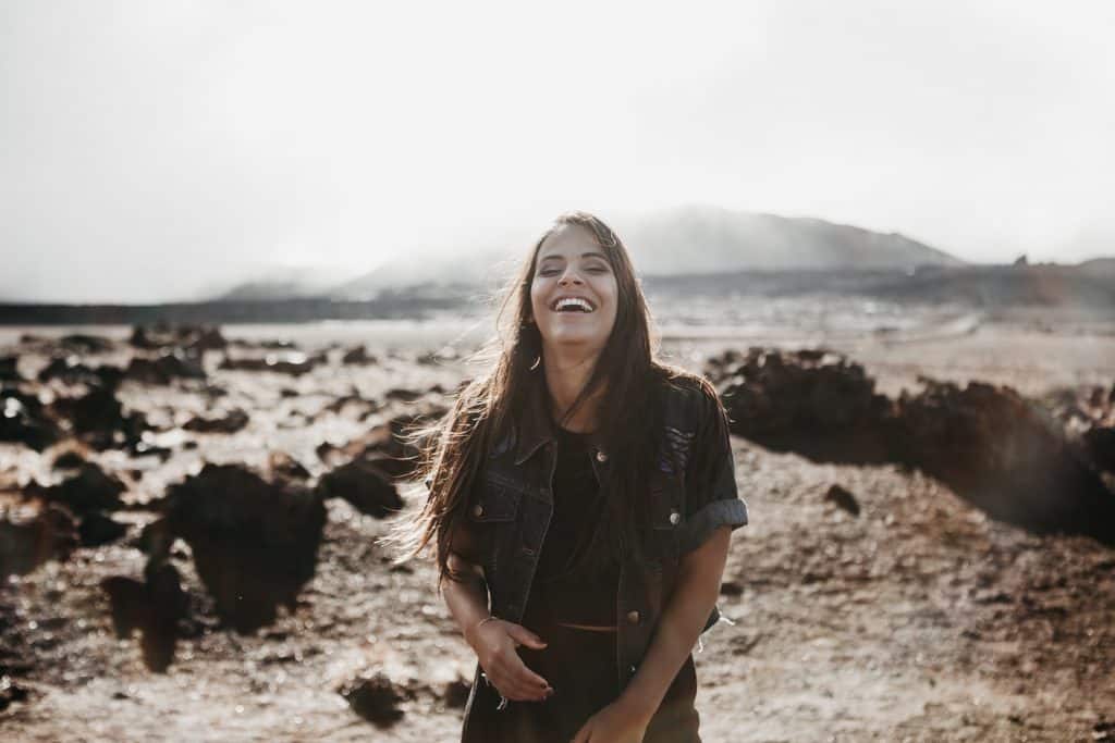 Mulher branca sorrindo meio a cenário caatinga