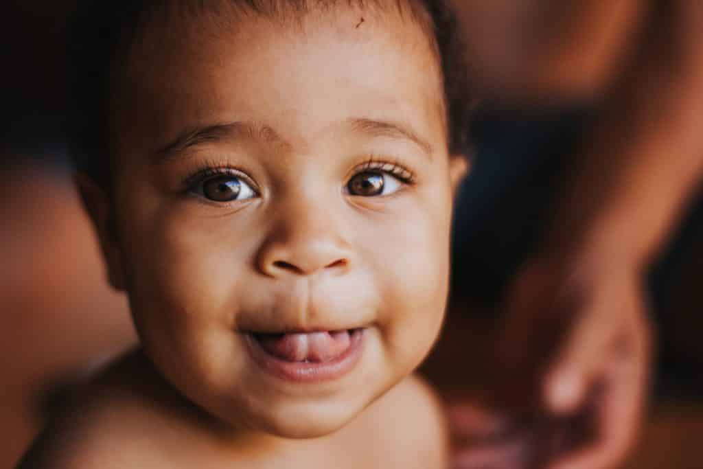 Bebê sorrindo olhando para o lado