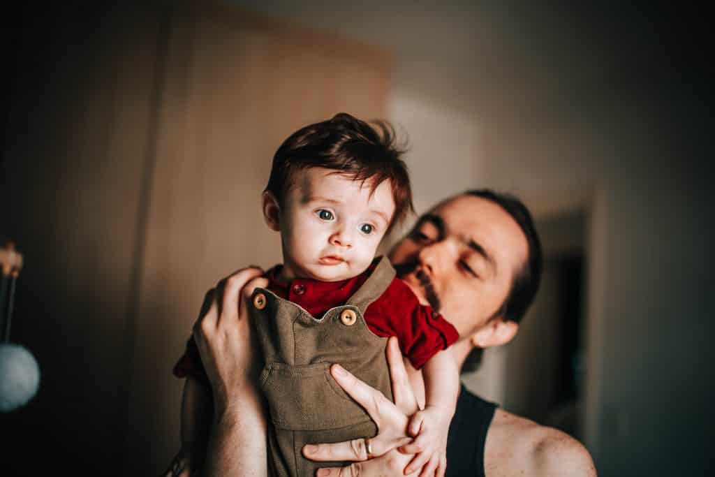 Pai segurando seu filho em seu quarto