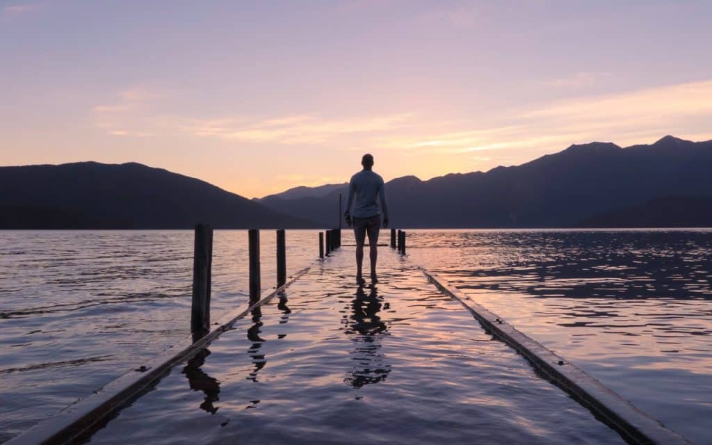 Homem em um pier de lago.