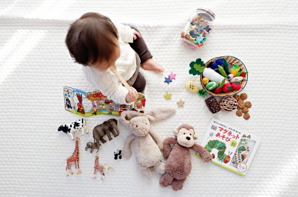 Bebê sentado no chão com brinquedos em sua frente