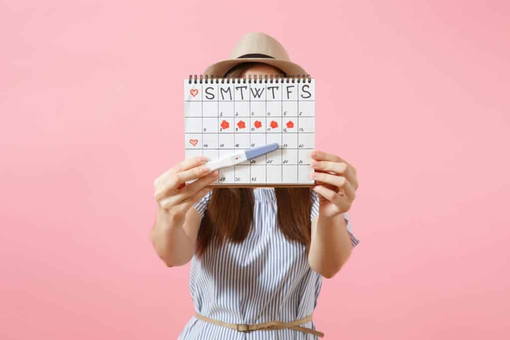 Mulher segurando calendário menstrual