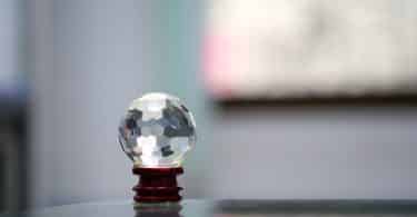 Cristal multifacetado: uma bola transparente em cima de um apoiador.