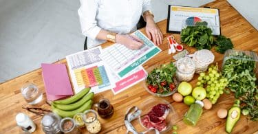 Nutricionista em sua mesa com alimentos na mesa