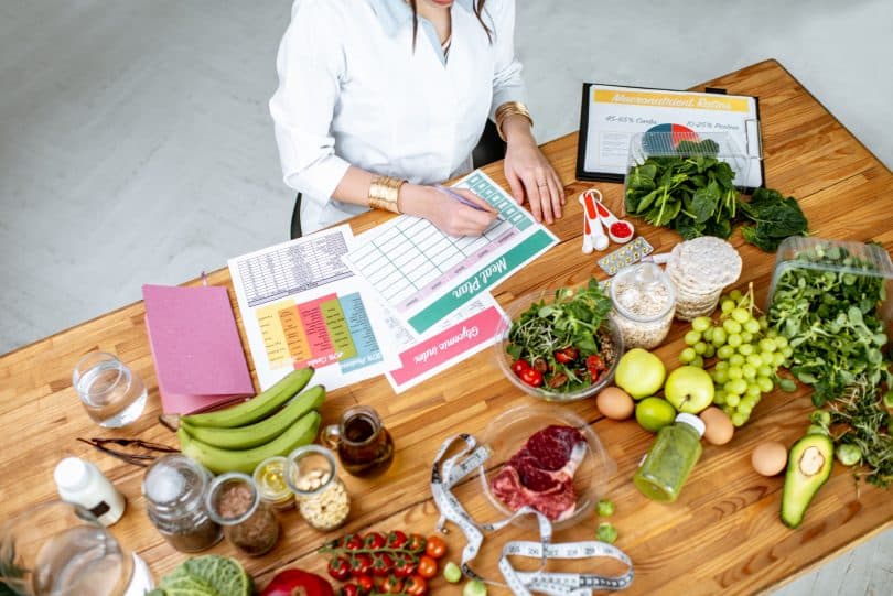 Nutricionista em sua mesa com alimentos na mesa