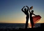 Silhueta de casal de dança com mar e pôr-do-sol ao fundo