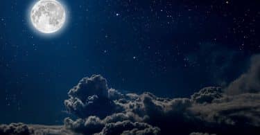 Céu noturno com uma lua cheia e nuvens.