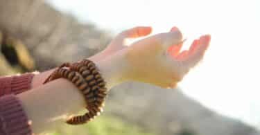 Imagem das mãos de uma mulher com as palmas para cima em sinal de meditação.