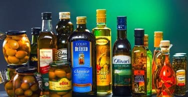 Imagem de várias garrafas de vidro cheias de azeites e outros tipos de óleos vegetais.