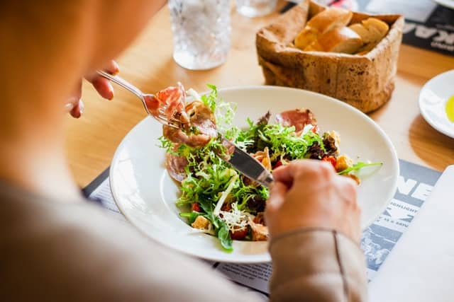 Homem almoçando prato com salada e comida saudável