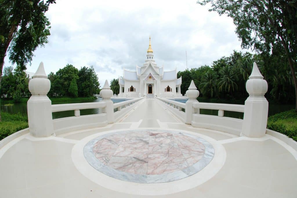 Imagem de um retiro espiritual em um templo budista. Trata-se de um prédio todo branco e muito grande.
