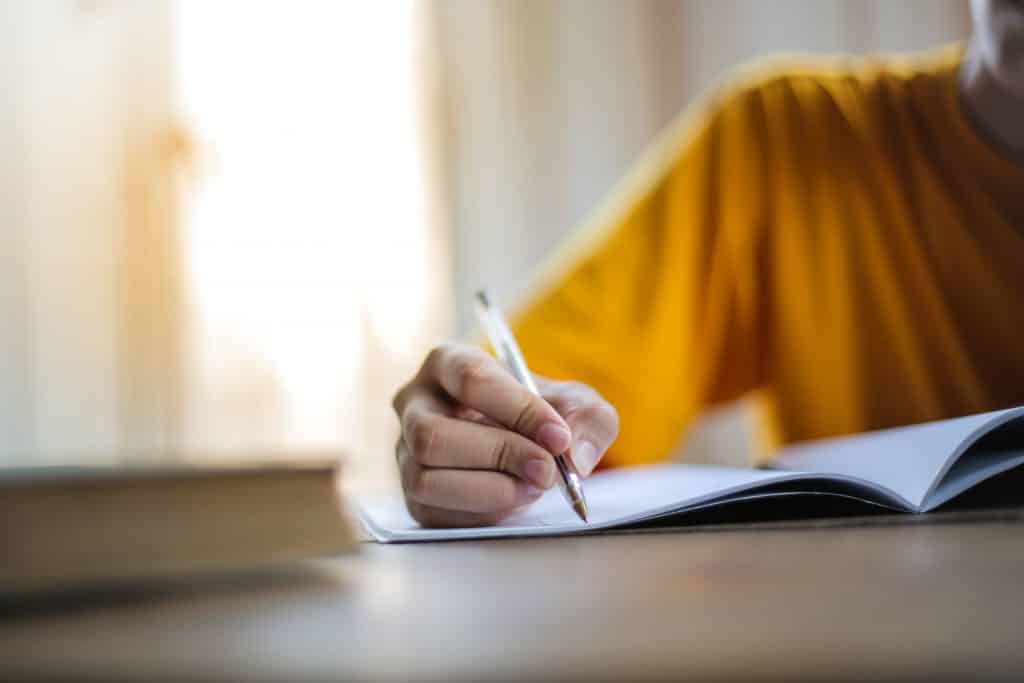 Mulher escrevendo em um caderno