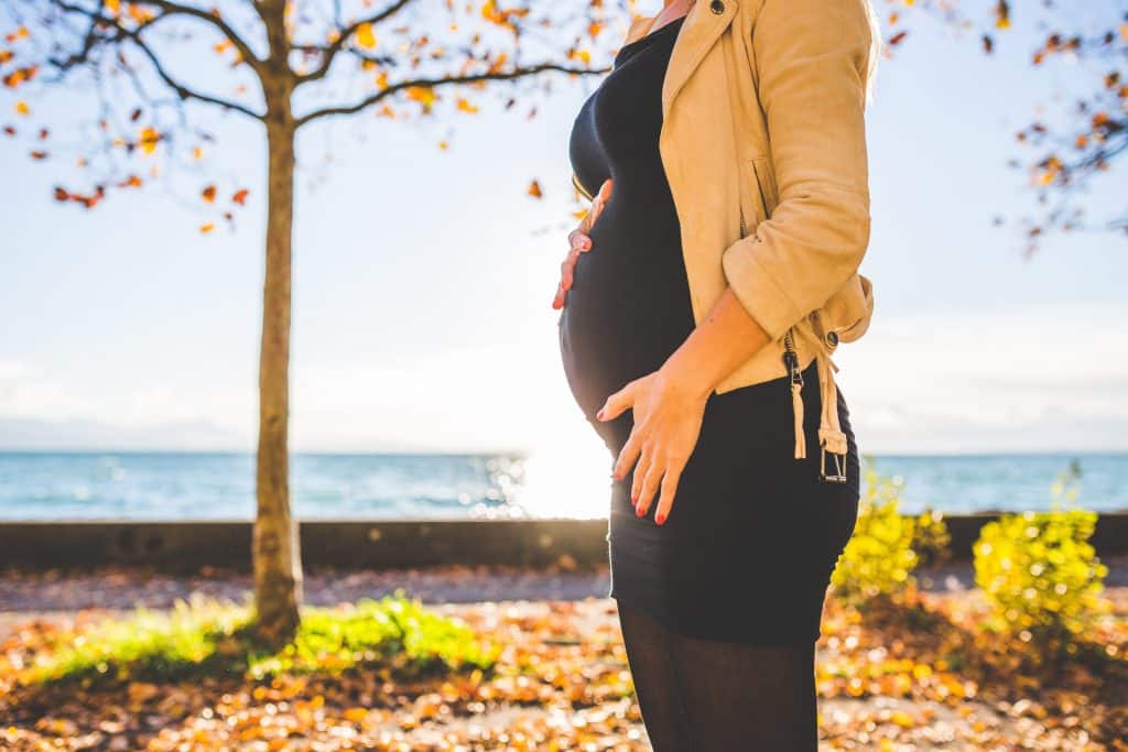 Mulher grávida com as mãos na barriga