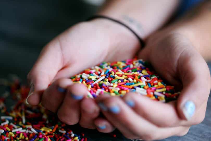 Mulher pegando com as duas mãos granulado colorido